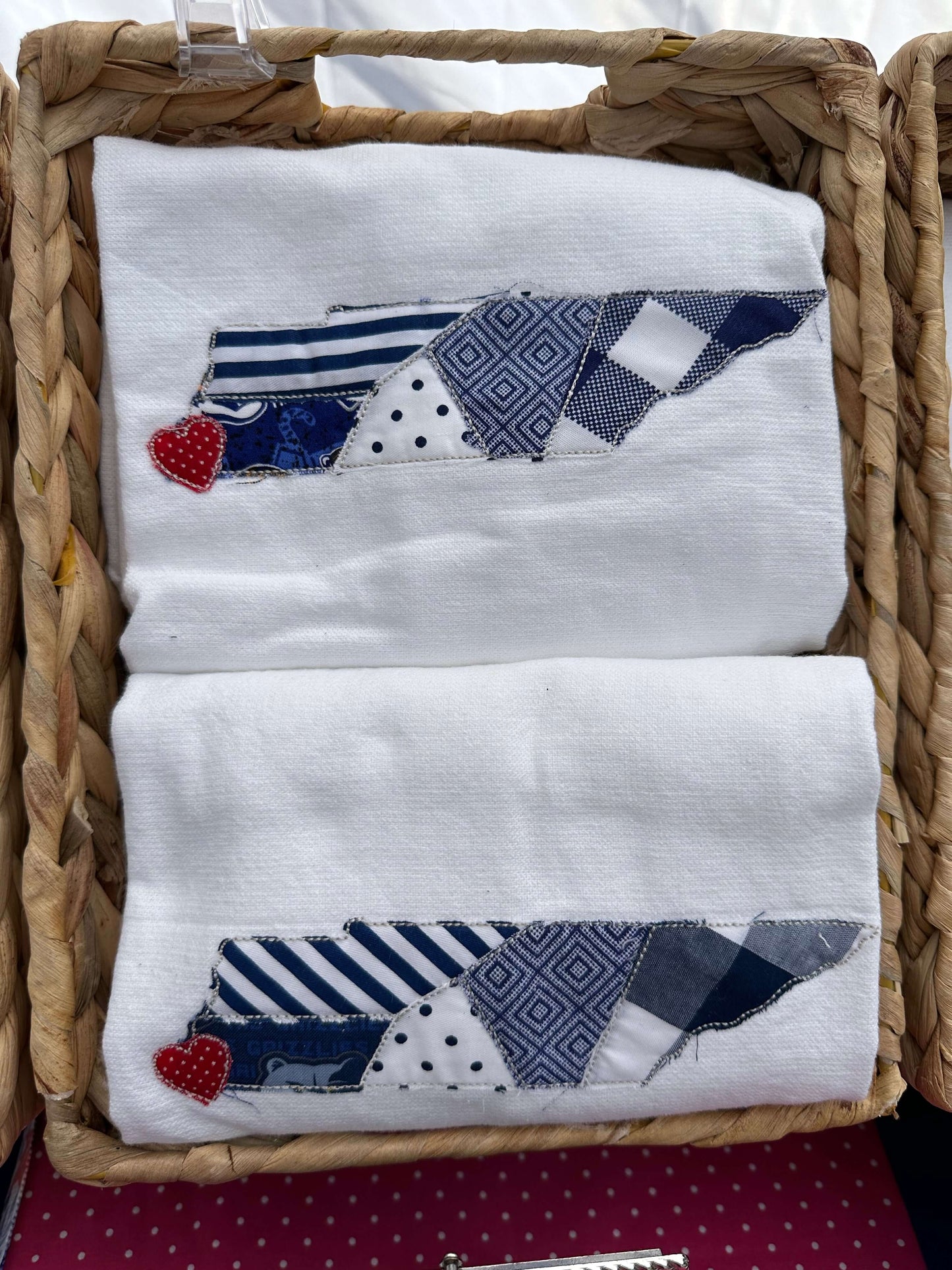 100% cotton tea towel featuring an appliqué of the state of tennessee in shades of blue fabric with a red heart sewn where memphis is - in the bottom left corner of the state.