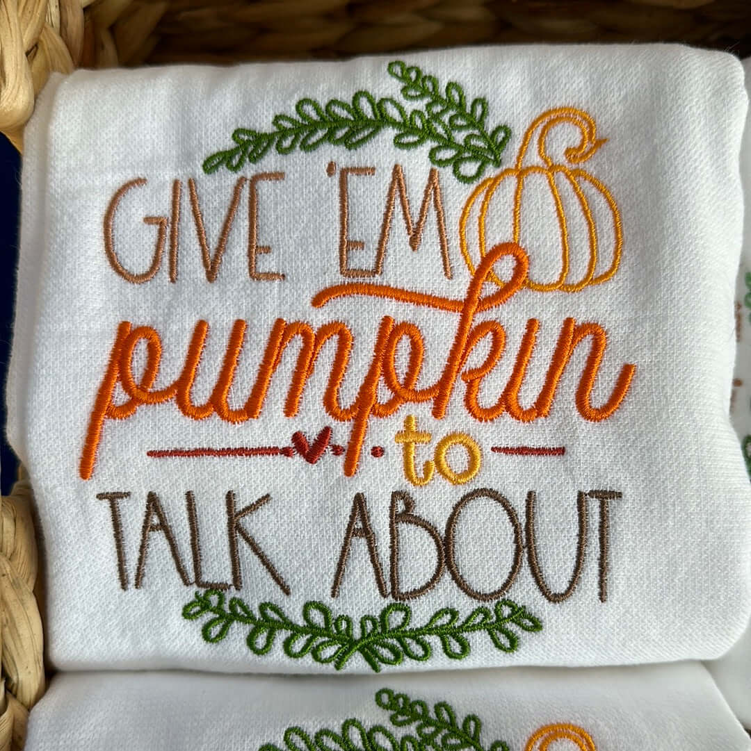 tea towel featuring the phrase, “give ‘em pumpkin’ to talk about” inspired by the bonnie rait song. features lovely fall colors